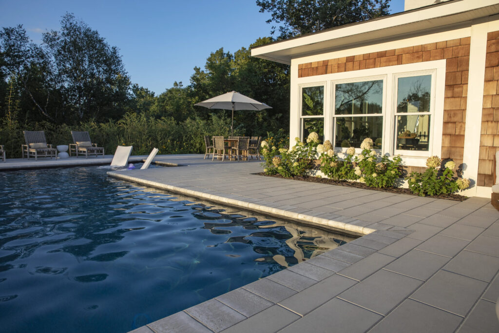 Backyard pool by modern house at sunset.