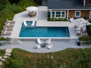 Backyard pool with patio and lounging chairs from above.