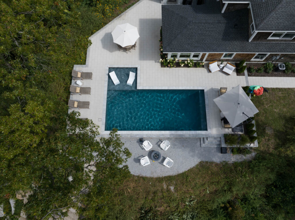 Aerial view of backyard with pool and patio area.