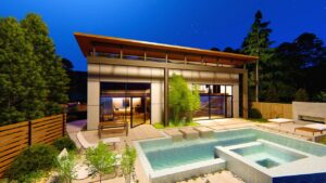 Modern pool house with gunite pool and elegant landscaping, showcasing a luxurious outdoor living space in Walled Lake, ideal for relaxation and entertainment.