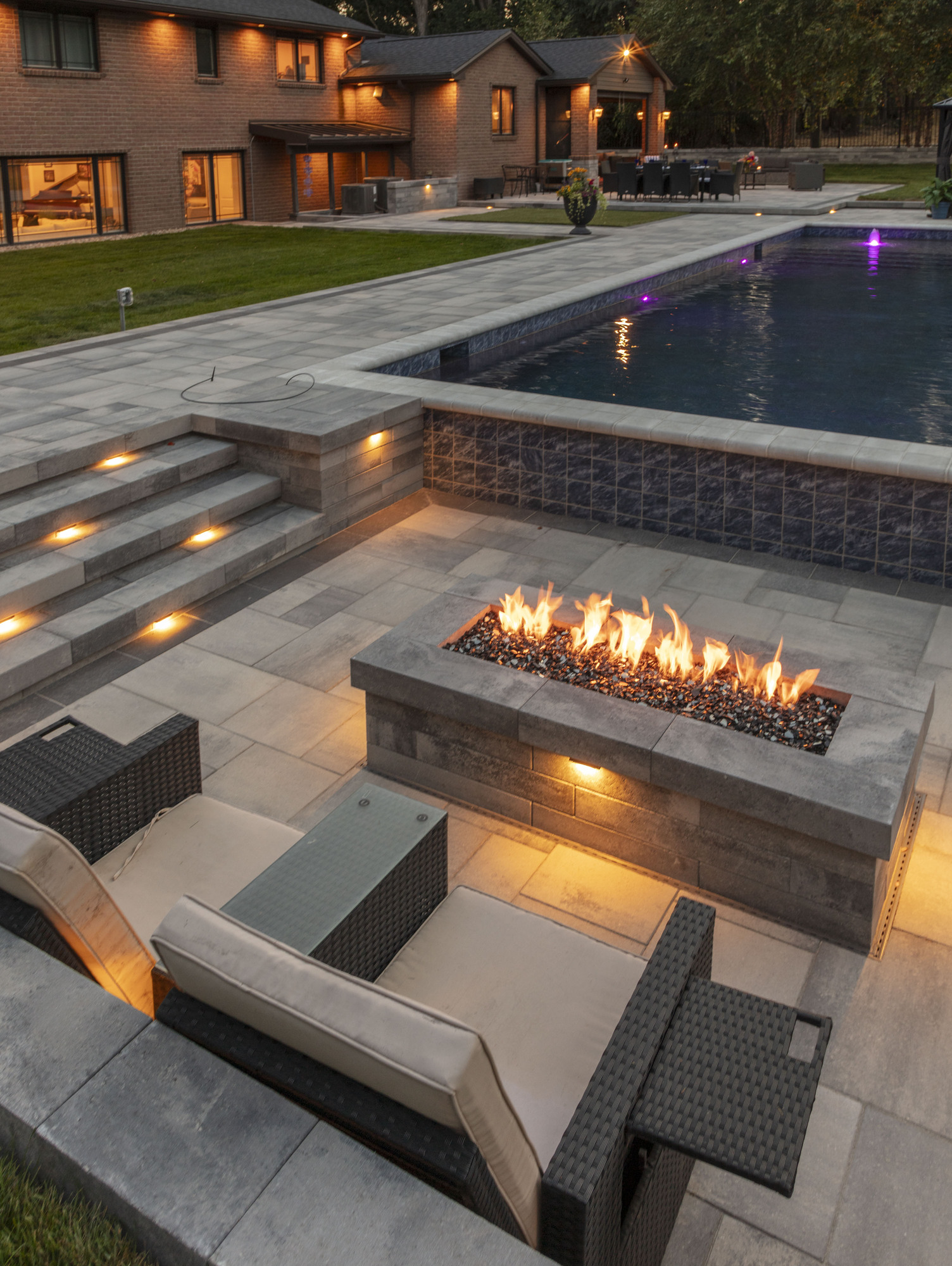 Luxury Gunite pool area with modern seating, fire pit, and landscaped backyard, showcasing Tango Pools' design expertise in Saint Clair Shores.