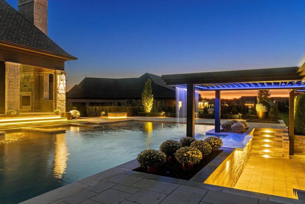 Luxurious gunite pool with modern landscaping, illuminated features, and a stylish pergola at dusk, showcasing Tango Pools' exceptional craftsmanship and design expertise.