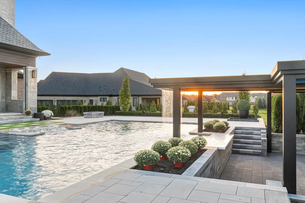 Luxury backyard with a swimming pool, landscaped garden, and sunset view.