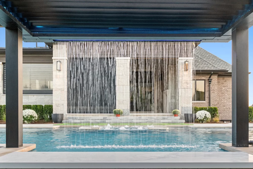 Custom pool deck blending brick pavers, stone accents, and integrated landscaping